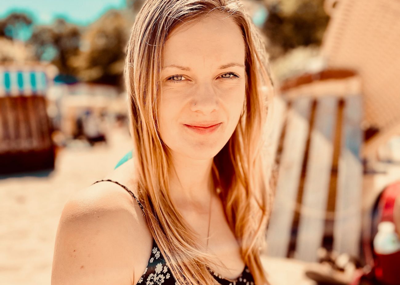 Alexandra entspannt lächelnd am Strand.