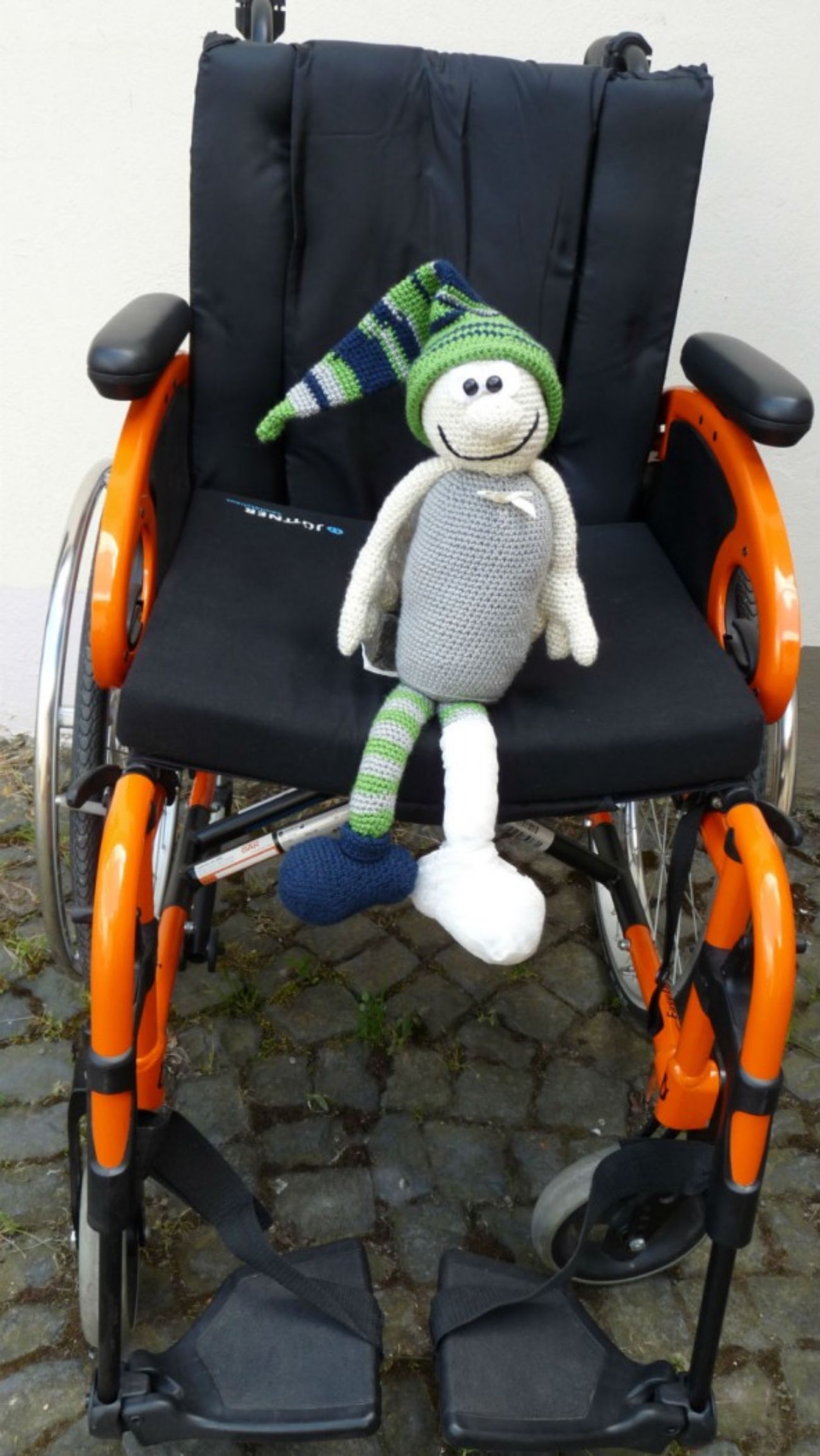 Puppe, die in einem Rollstuhl sitzt