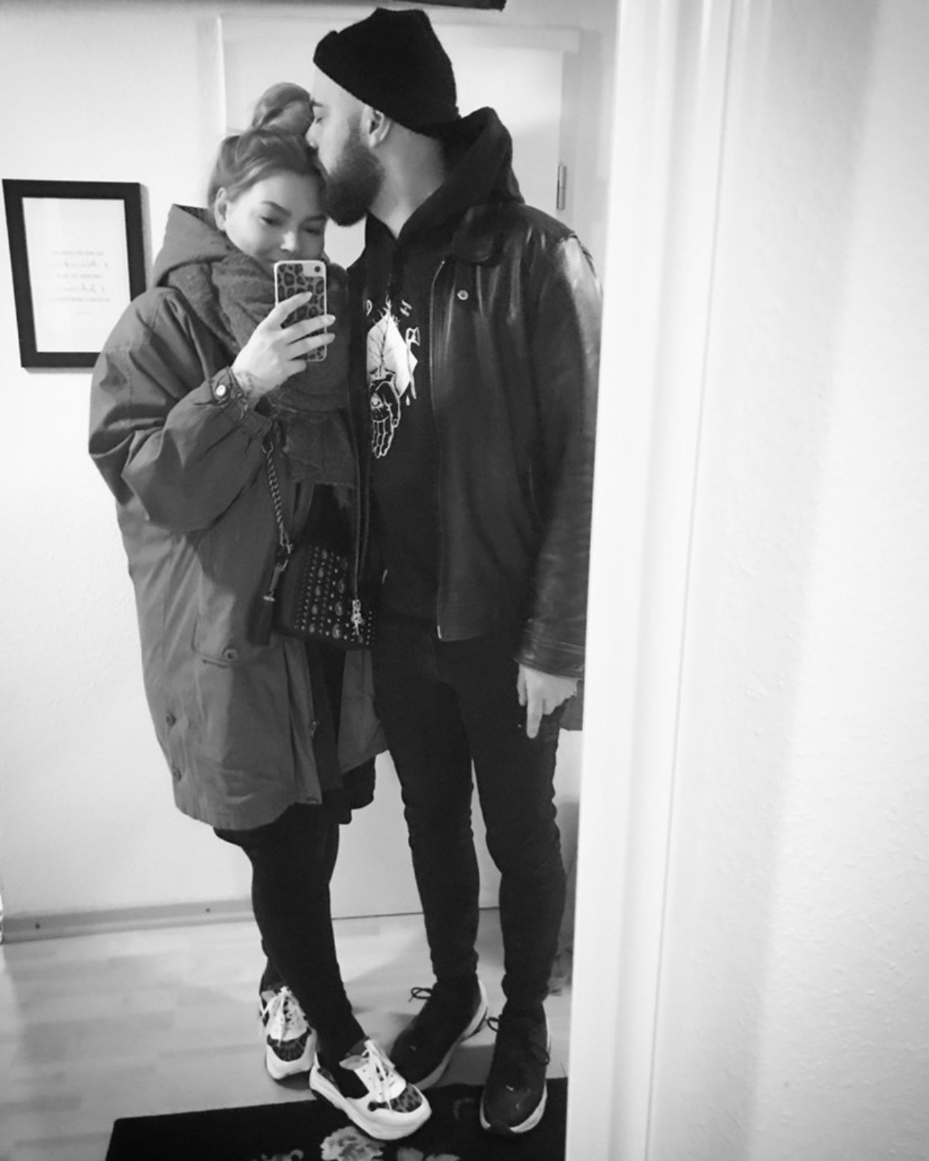 Selfie von Kira und Thomas mit angezogenen Jacken in der Wohnung.