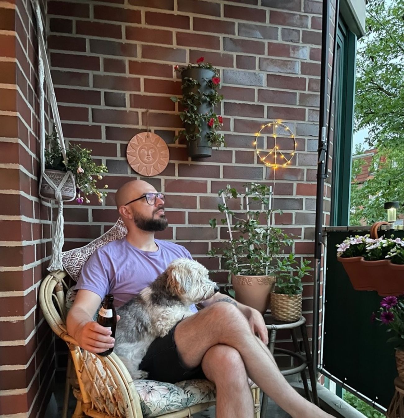 Thomas und Hund Ingo sitzen in einem Stuhl auf dem Balkon.