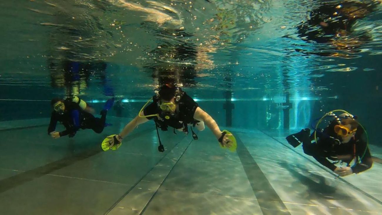 Nicole tauchend im Wasserbecken mit Handpaddles