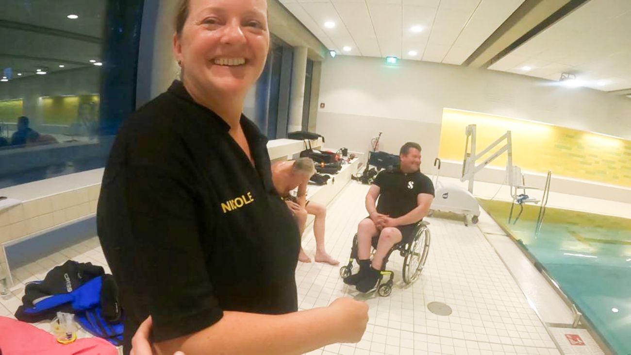Nicole mit Rolli-Fahrer am Beckenrand im Schwimmbad