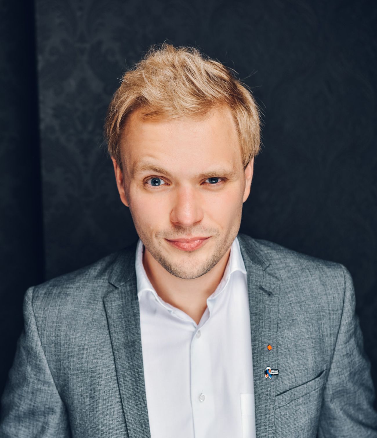 Christian im Anzug mit kritisch hochgezogener Augenbraue