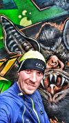 Ein Selfie von Chris vor einer bemalten Mauer