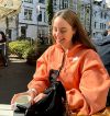 Elena lachend draußen in einem Café.