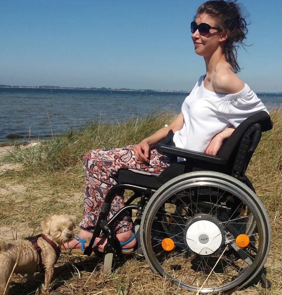 Janine im Rolli am Meer mit ihrem Hund